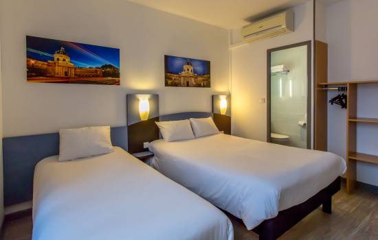un lit simple et un lit double dans une chambre d'hotel