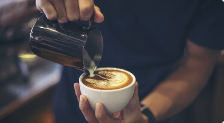 une personne serre un café crème